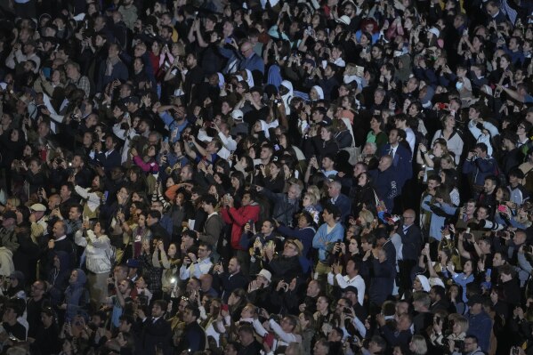 People react in St. Peter's Square at the Vatican after black smoke billowed from the chimney of the Sistine Chapel, where 133 cardinals are gathering on the first day of the conclave, indicating that a successor of late Pope Francis was not elected, Wednesday, May 7, 2025. (AP Photo/Markus Schreiber)