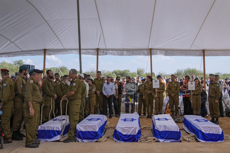 Những người đưa tang tập trung quanh năm chiếc quan tài của gia đình Kotz trong lễ tang của họ ở Gan Yavne, Israel, Thứ Ba, ngày 17 tháng 10 năm 2023. Gia đình này đã bị phiến quân Hamas giết chết vào ngày 7 tháng 10 tại nhà của họ ở Kibbutz Kfar Azza gần biên giới với Dải Gaza, Hơn 1.400 người đã thiệt mạng và khoảng 200 người bị bắt trong một cuộc tấn công đa mặt trận chưa từng có của nhóm chiến binh cai trị Gaza.  (Ảnh AP/Ohad Zwigenberg)