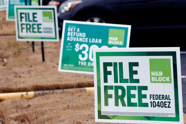FILE- In this Feb. 14, 2018, file photo, H&R Block signs are displayed in Jackson, Miss. Congressional Democrats are accusing big tax preparation firms including Intuit and H&R Block of undermining the federal government's upcoming electronic free-file tax return system, and are demanding lobbying, hiring and revenue data to determine what's going on. (AP Photo/Rogelio V. Solis, File)