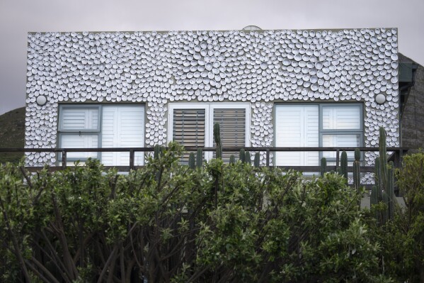 Abalone shells cover the facade of a house in the seaside fishing village of Hawston, South Africa, April 27, 2023. Abalone here was abundant, yet the demand largely put the village and its traditional fishers out of business, or made them criminals overnight.(AP Photo/Jerome Delay)