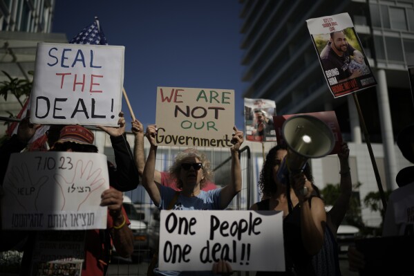 Families and supporters of Israeli hostages held by Hamas in Gaza hold banners and flags during a protest calling for their return, outside meetings of U.S. Secretary of State Antony Blinken in Tel Aviv, Israel, Tuesday, June 11, 2024. (AP Photo/Leo Correa)