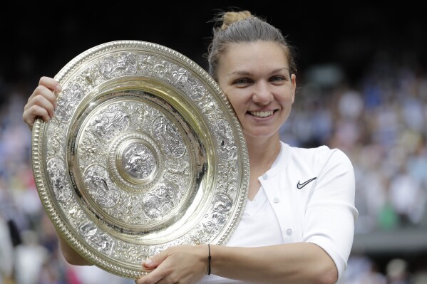 FILE - Romania's Simona Halep holds the trophy after defeating Serena Williams in the women's singles final of the Wimbledon Tennis Championships in London, July 13, 2019. Two-time Grand Slam champion Simona Halep has been suspended from professional tennis for four years for alleged doping violations, the International Tennis Integrity Agency said Tuesday, Sept. 12, 2023. (AP Photo/Ben Curtis, File)