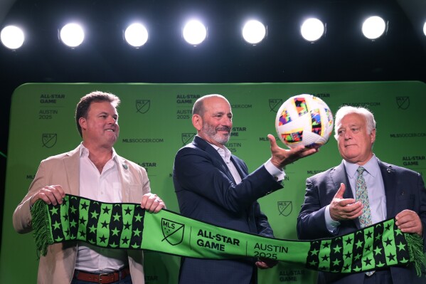 Major League Soccer Commissioner Don Garber, center, catches a soccer ball as he stands with Majority Owner and Chief Executive Officer of Austin FC Anthony Precourt, left, and Austin Mayor Kirk Watson, right, after announcing that Austin FC will host the 2025 MLS All-Star soccer game, Wednesday, May 15, 2024, in Austin, Texas. (AP Photo/Eric Gay)