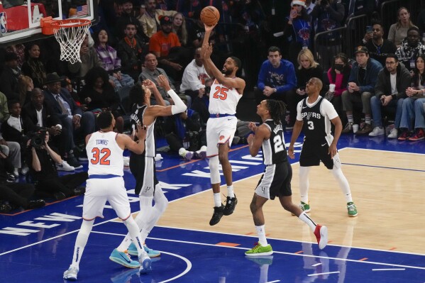 New York Knicks' Mikal Bridges, center, puts up a shot during the first half of an NBA basketball game against the San Antonio Spurs, Wednesday, Dec. 25, 2024, in New York. (AP Photo/Seth Wenig)