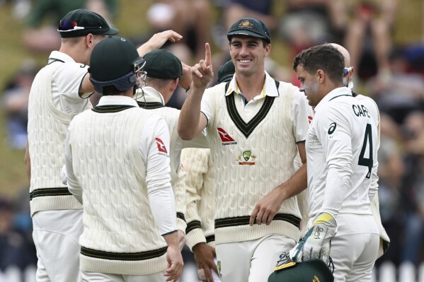 Australia's captain Pat Cumins celebrates the wicket of New Zealand batsman Tom Blundell with teammates on day four of the first cricket test match between New Zealand and Australia at the Basin Reserve in Wellington, New Zealand, Sunday, March 3, 2024. Australia defeated New Zeaalnd by 172 runs.(Andrew Cornaga/Photosport via AP)