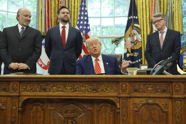 President Donald Trump, center, with from l-r., Commerce Secretary Howard Lutnick, Vice President JD Vance, and Britian's ambassador to the United States Peter Mandelson, making remarks on a trade deal between U.S. and U.K. in the Oval Office of the White House, Thursday, May 8, 2025, in Washington. (AP Photo/Evan Vucci)