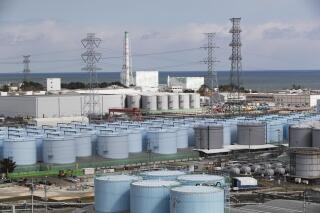 FILE - In this Saturday, Feb. 27, 2021, file photo, Nuclear reactors of No. 5, center left, and 6 look over tanks storing water that was treated but still radioactive, at the Fukushima Daiichi nuclear power plant in Okuma town, Fukushima prefecture, northeastern Japan. (AP Photo/Hiro Komae, file)