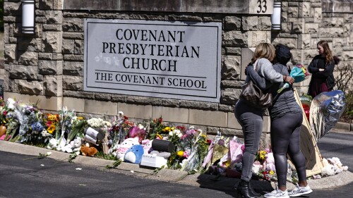 ARCHIVO - Dos mujeres se besan frente a un monumento en la entrada de la Escuela Covenant el miércoles 29 de marzo de 2023 en Nashville, Tennessee.  En Tennessee, una solicitud para que la policía divulgue los escritos privados de un tirador en la escuela se ha convertido en una pelea legal compleja y multipartidista.  En ausencia de un estándar nacional sobre cómo manejar estos documentos, ambas partes dicen que su posición es de interés público.  (Foto AP/Wade Payne, archivo)