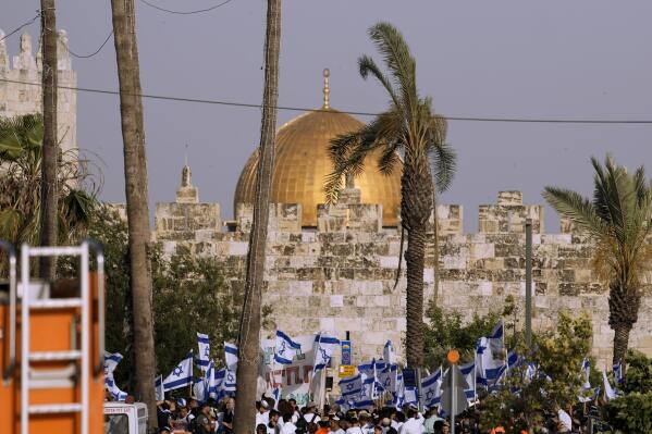 FILE - Israelis wave national flags in front of Damascus Gate outside Jerusalem's Old City to mark Jerusalem Day, an Israeli holiday celebrating the capture of the Old City during the 1967 Mideast war, Sunday, May 29, 2022. The ruling Hamas militant group in the Gaza Strip on Wednesday, May 17, 2023, called on Palestinians to confront a flag-waving parade planned by Jewish nationalists through the main Palestinian thoroughfare in Jerusalem’s Old City.(AP Photo/Ariel Schalit)