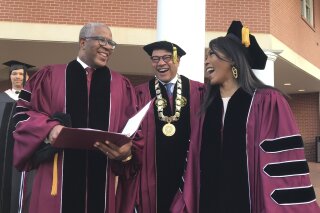 
              Robert F. Smith, left, laughs with David Thomas, center, and actress Angela Bassett at Morehouse College on Sunday, May 19, 2019, in Atlanta. Smith, a billionaire technology investor and philanthropist, said he will provide grants to wipe out the student debt of the entire graduating class at Morehouse College - an estimated $40 million. Smith, this year's commencement speaker, made the announcement Sunday morning while addressing nearly 400 graduating seniors of the all-male historically black college in Atlanta.  (Bo Emerson/Atlanta Journal-Constitution via AP)
            