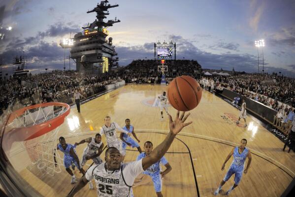 FILE - In this image taken with a fisheye lens, Michigan State center Derrick Nix (25) grabs a rebound in front of North Carolina forward John Henson (31), right, during the first half of the Carrier Classic NCAA college basketball game aboard the USS Carl Vinson, Friday, Nov. 11, 2011, in Coronado, Calif. They're going to try to play college basketball on an aircraft carrier again, and Tom Izzo and the Michigan State Spartans will get a return trip to San Diego Bay to face Gonzaga on the flight deck of the USS Abraham Lincoln on Nov. 11, 2022. (AP Photo/Mark J. Terrill, File)