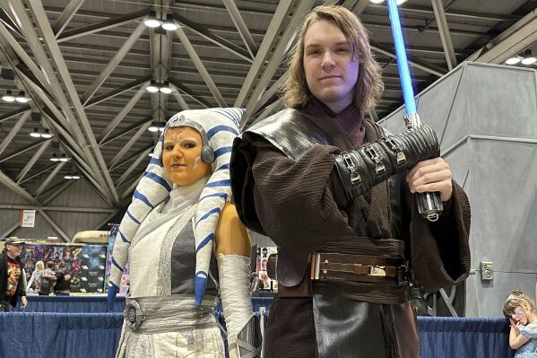 Courtney, left and Josh Thornton from Tulsa, Okla. dressed as Ahsoka Tano and Anakin Skywalker from the Star Wars franchise attend the 25th annual Planet Comicon Kansas City on Friday, March 8, 2024 in Kansas City, Mo.. Planet Comicon Kansas City is a weekend long event featuring cosplayers, artists, celebrity guests, comic book creators and more for fans of all areas of pop culture. (AP Photo/Nick Ingram)
