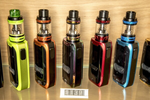 This shows a row of vapes in an Auckland store, on Feb. 11, 2018. The New Zealand Government said Wednesday, March 20, 2024, that it will ban disposable e-cigarettes, or vapes, and raise financial penalties for those who sell such products to minors. (Michael Craig/New Zealand Herald via AP)