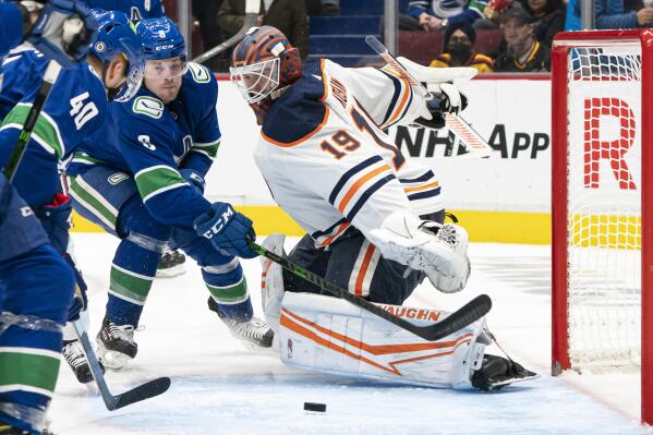 Vancouver Canucks' Brock Boeser, left, loses control of the puck as Edmonton Oilers goalie Mikko Koskinen defends during the second period of an NHL hockey game Saturday, Oct. 30, 2021, in Vancouver, British Columbia. (Rich Lam/The Canadian Press via AP)