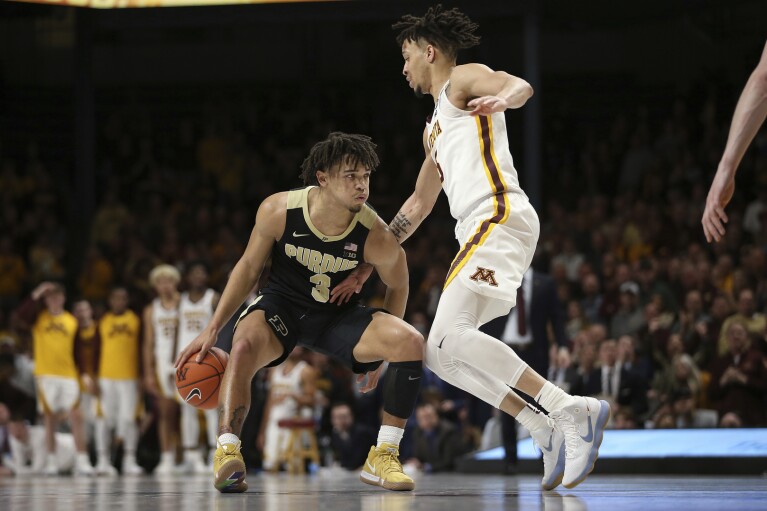 Purdue's Carsen Edwards, left, controls the ball against Minnesota's guard Amir Coffey, right, during the second half of an NCAA basketball game Tuesday, March 5, 2019, in Minneapolis. Minnesota won 73-69. (AP Photo/Stacy Bengs)