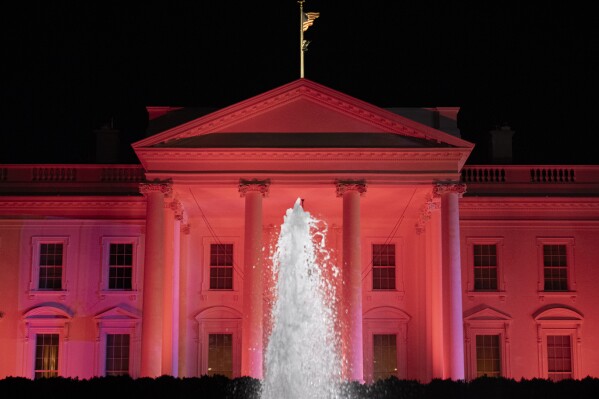The White House is illuminated in pink for Breast Cancer Awareness Month, Thursday, Oct. 19, 2023, in Washington. (AP Photo/Andrew Harnik)