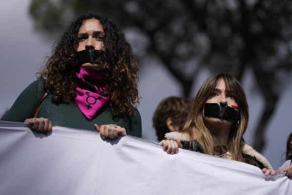 Women have black tape on their mouths during a march on the occasion of International Women's Day, in Rome, Friday, March 8, 2024. Marches, demonstrations and conferences are being held the world over, from Asia to Latin America and elsewhere to mark International Women's Day. (AP Photo/Alessandra Tarantino)