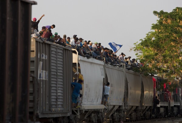 ARCHIVO - Migrantes centroamericanos montados sobre un tren de carga en su ruta hacia la frontera entre México y Estados Unidos, en Ixtepec, en el estado de Oaxaca, México, el 23 de abril de 2019. Ferromex, la mayor empresa ferroviaria de México, anunció el martes 19 de septiembre de 2023 que suspendía sus operaciones en 60 trenes de carga debido al masivo flujo de migrantes que viajan de forma irregular en los trenes de carga en su ruta hacia la frontera norte que linda con Estados Unidos. (AP Foto/Moisés Castillo, Archivo)