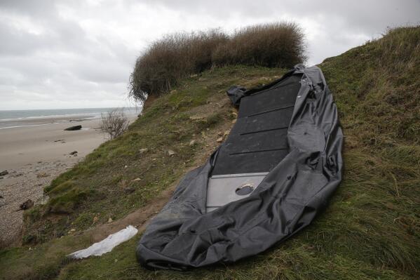 FILE - A damaged inflatable small boat is pictured on the shore in Wimereux, northern France, Thursday, Nov. 25, 2021 in Calais, northern France. The Paris prosecutor’s office said it has received a manslaughter lawsuit for failure to help in the tragic capsizing last month of a boat in the English Channel that cost the lives of at least 27 people trying to reach Britain. The manslaughter lawsuit, filed Friday, Dec. 17, 2021 by the French humanitarian organization Utopia 56, accuses the maritime prefect of the Channel and North Sea, the Regional Operational Centre for Surveillance and Rescue of Gris-Nez in the Pas-de-Calais and the British Coast Guard of not doing enough to prevent the deaths. (AP Photo/Michel Spingler, File)