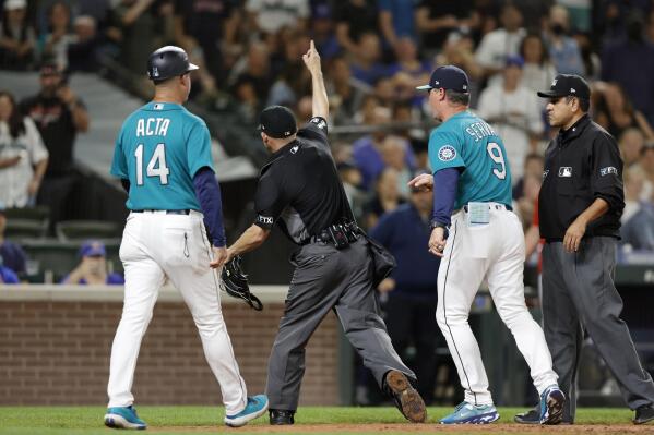 Seattle Mariners' Eugenio Suarez blows a bubble while on the bench