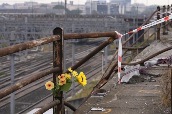 FILE - A bunch of plastic flowers is seen at the scene of a passenger bus accident in Mestre, near the city of Venice, Italy, Wednesday, Oct. 4, 2023. Prosecutors on Thursday, Oct. 5, 2023 said they have ordered an expert examination of an overpass guardrail that gave way when struck by a shuttle bus that plunged nearly 10 meters, killing 20 foreign tourists and the driver. (AP Photo/Antonio Calanni, File)
