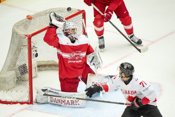 Canada's Tyson Foerster, right, challenges Denmark goalkeeper Frederik Dichow during the IIHF 2025 World Championship quarterfinal match between Denmark and Canada in Herning, Denmark, Thursday, May 22, 2025. (Bo Amstrup/Ritzau Scanpix via AP)