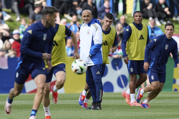 FILE - Italy's head coach Luciano Spalletti, center, follows the Italian national soccer team's public training session in Iserlohn, Germany, Tuesday, June 11, 2024. The Italy coach has been portrayed as quite the disciplinarian for urging his players to get more sleep instead of playing videos games. Indeed, striker Gianluca Scamacca was reportedly dropped from the squad in March because of an obsession with his PlayStation. (Bernd Thissen/dpa via AP, File)