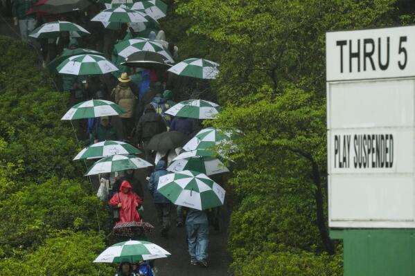 Patrons leave the course after play was suspended in the weather delayed third round of the Masters golf tournament at Augusta National Golf Club on Saturday, April 8, 2023, in Augusta, Ga. (AP Photo/Charlie Riedel)