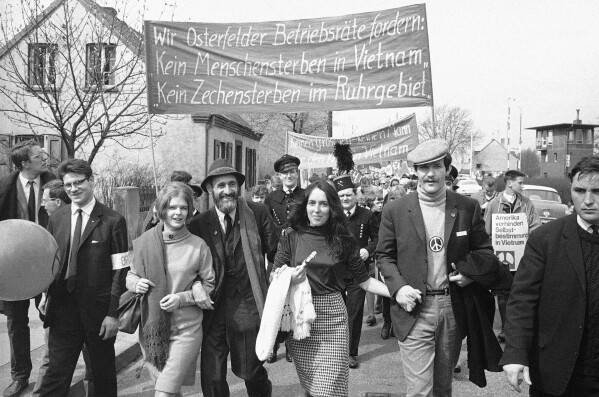 Joan Baez, center, U.S. folk singer, heads a column of Easter marchers during this years Ban the Bomb campaign in Essen, Germany, April 10, 1966. Marchers carry poster reading "No Dying of Men in Vietnam, No Dying of Coal Mines in the Ruhr District", a protest against the present closure of several coal mines. (AP Photo, File)