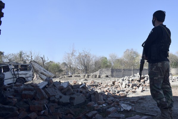 A police officer examines the damage at the site of Tuesday's suicide bombing, in Bannu, in northwestern Pakistan, Wednesday, March 5, 2025. (AP Photo/Ijaz Muhammad)