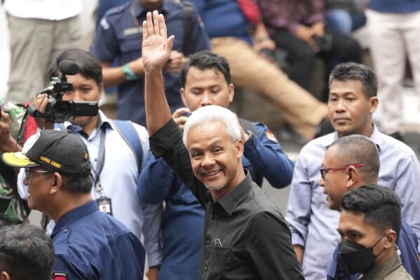 Presidential candidate Ganjar Pranowo, center, waves at photographers as he arrives to attend the "Declaration of Peaceful Election Campaign" at the General Election Commission Building, in Jakarta, Indonesia, Monday, Nov. 27, 2023. Presidential candidates in the world's third-largest democracy will kick off their campaign period on Nov. 28 ahead of the country's simultaneous legislative and presidential elections in February 2024. (AP Photo/Tatan Syuflana)