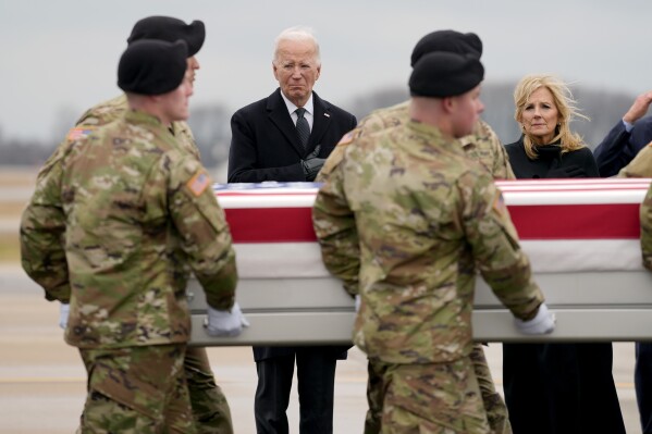 Президентът Джо Байдън, третият вляво, и първата дама Джил Байдън, вдясно, стоят, докато армейски екип премества транспортната чанта, съдържаща останките на сержант от армията на САЩ.  Кенеди Ладон Сандърс, 24, от Уейкрос, Джорджия, във военновъздушната база Доувър, Делауеър, петък, 2 февруари 2024 г. Сандърс беше убит при нападение с дрон в Йордания на 28 януари.  (AP Photo/Мат Рурк)