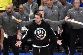 Luka Doncic, de los Mavericks de Dallas, observa a un árbitro desde la banca, durante el juego 1 de la serie de playoffs entre su equipo y el Jazz de Utah, el sábado 16 de abril de 2022, en Dallas. (AP Foto/Tony Gutierrez)